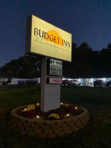 um sinal para uma empresa de buggies num campo em Budget Inn em Dayville
