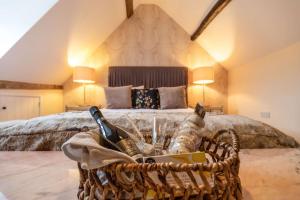 een slaapkamer met een bed en een mand met wijnflessen bij The Cotswold Lady in Guiting Power