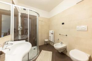 a bathroom with a sink and a toilet and a shower at Residence Adler in San Martino di Castrozza