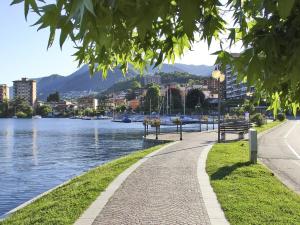 オメーニャにあるCasa al lagoの二つのベンチを備えた水の横の歩道