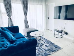 a living room with a blue couch and a table at The Blyde Crystal Lagoon Bliss in Pretoria