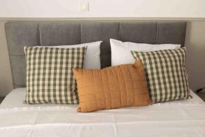 a bunch of pillows sitting on a bed at Luxury apartment in the center of Xanthi in Xanthi