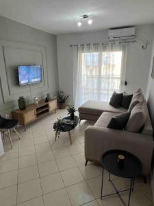 a living room with a couch and a tv at Luxury apartment in the center of Xanthi in Xanthi