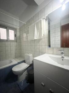 uma casa de banho com um WC branco e um lavatório. em Luxury apartment in the center of Xanthi em Xanthi