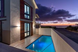 a swimming pool on the side of a house at Hermanus Beach House at CShine in Hermanus