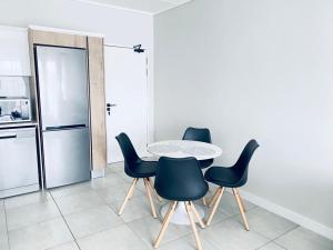 een keuken met een tafel en stoelen en een koelkast bij The Blyde Crystal Lagoon Bliss in Pretoria