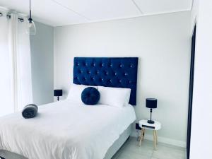 een slaapkamer met een groot bed met een blauw hoofdeinde bij The Blyde Crystal Lagoon Bliss in Pretoria