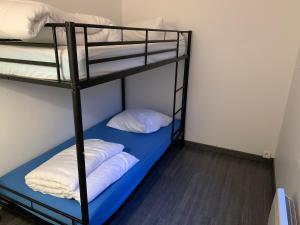 Pokój z 2 łóżkami piętrowymi i białymi poduszkami w obiekcie Chez Elo w mieście Le Tréport