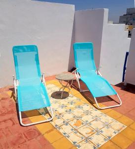 two blue chairs and a table on a tile floor at Maison de la Lagune in Oualidia