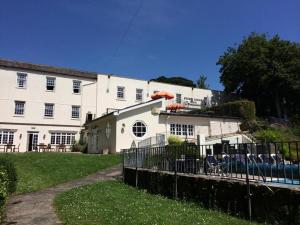 a large white building with a fence in front of it at Stoke Lodge Hotel in Stoke Fleming