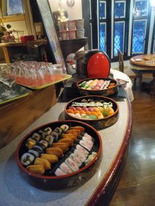 a buffet with three trays of sushi on a table at プチホテル葡萄屋 in Hakuba