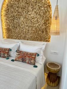 a bedroom with a bed with two pillows and a table at Thealos Santorini ( close to square) in Pirgos