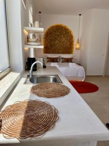 a kitchen counter with a sink and two towels at Thealos Santorini ( close to square) in Pyrgos