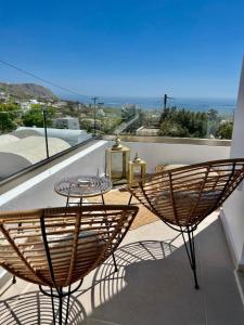 a patio with a table and chairs on a balcony at Thealos Santorini ( close to square) in Pyrgos