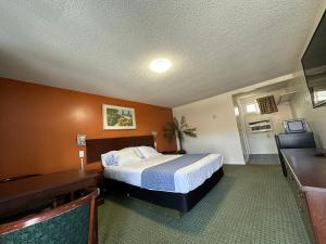 um quarto de hotel com uma cama e uma secretária em Budget Inn em Dayville