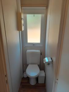 a small bathroom with a toilet and a window at La Muela in Cádiz
