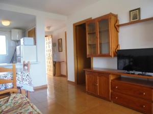 a living room with a flat screen tv and a kitchen at Patios I in Peniscola