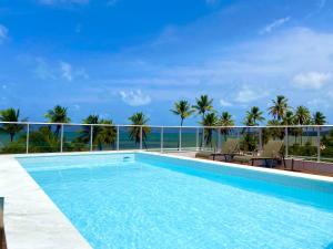 a swimming pool with a view of the ocean at PUERTO VENTURA Flat - Cabo Branco by PenareiaTurBr in João Pessoa