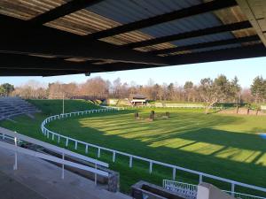 a grassy field with a fence and horses in it at Le colibri in Dinard