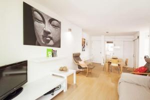 un soggiorno bianco con TV a schermo piatto di Fantástico apartamento con WIFI a Port de Pollença