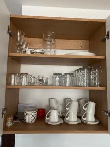 a cupboard filled with lots of dishes and glasses at Lake apartment Zefir 15 in Augustów