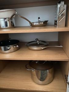 a kitchen shelf with a sink and pots and pans at Lake apartment Zefir 15 in Augustów