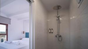 a bathroom with a shower and two beds in it at Castell de Lô in Cala en Porter