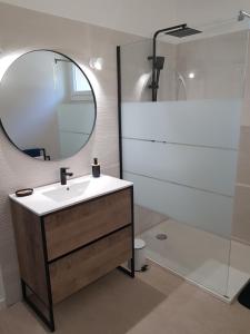 een badkamer met een wastafel en een spiegel bij LE PATIO in Sarrians