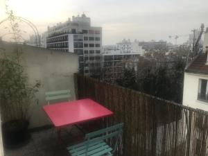 un tavolo rosa su un balcone con vista sulla città di Grand appartement avec terrasse, Paris12 a Parigi