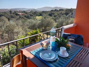 a table with a plate of food on a balcony at Casa Stefano 2 in Lu Lioni