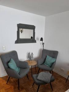 Duas cadeiras e uma mesa num quarto com um espelho em Appartement Wiesel em Sankt Andreasberg