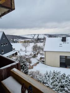 uma vista para uma cidade coberta de neve a partir de uma varanda em Appartement Wiesel em Sankt Andreasberg