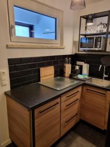 uma cozinha com um balcão preto e um lavatório em Appartement Wiesel em Sankt Andreasberg