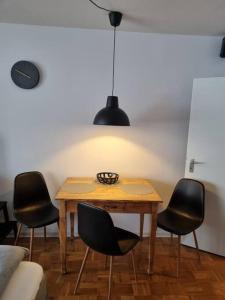 uma mesa de jantar com quatro cadeiras e um candeeiro em Appartement Wiesel em Sankt Andreasberg