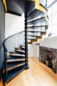 a black spiral staircase in a room with wooden floors at Les Lofts St-Pierre - Par Les Lofts Vieux-Québec in Quebec City