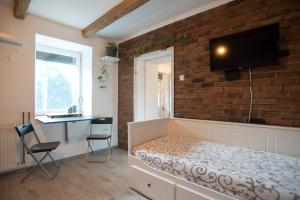 ein Schlafzimmer mit einer Ziegelwand, einem Bett und einem Schreibtisch in der Unterkunft Nordic Dream Apartment in Kikinda in Kikinda