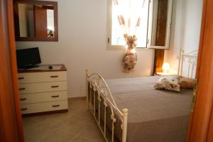 ガリポリにあるAttico Baia Verdeのベッドルーム1室(ベッド1台、ドレッサー、窓付)