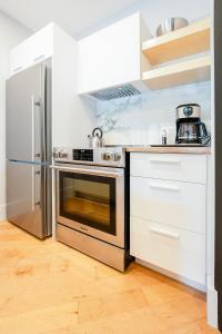 a kitchen with a stainless steel stove and refrigerator at Les Lofts St-Pierre - Par Les Lofts Vieux-Québec in Quebec City