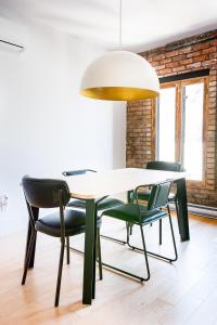 - une salle à manger avec une table et quatre chaises dans l'établissement Les Lofts St-Pierre - Par Les Lofts Vieux-Québec, à Québec