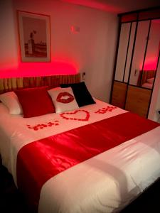 una camera da letto con un letto con luci rosse di Adorable Guest House avec balnéo et piscine a Olonne-sur-Mer