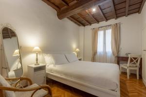 een slaapkamer met een bed, een spiegel en een stoel bij Signoria Florentine Apartment in Florence