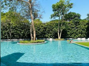 a swimming pool in a park with trees at Cosy seaview two bedrooms Nakula in North Pattaya