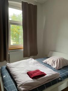a bed with a red towel on it in front of a window at Lovely room in Düsseldorf nearly Düsseldorf Hbf in Düsseldorf +6 photos