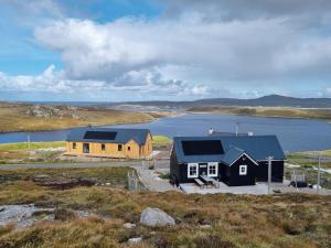 a house with solar panels on it next to a body of water at Hona in Mangersta