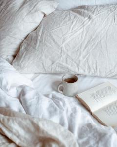 filiżankę kawy i książkę na łóżku w obiekcie KeRo Luxury Rooms w Cagliari
