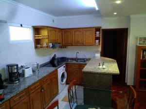 cocina con armarios de madera y encimera en Casa MAR, en Madalena do Mar