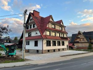 una casa grande con techo rojo en una calle en Apartament Krystynka Giewont, en Poronin