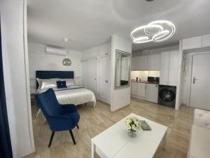 um quarto com uma cama, uma cadeira azul e uma mesa em Acapulco playa Nerja 407 planta superior em Nerja