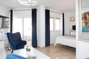 a bedroom with a bed and a blue chair at Acapulco playa Nerja 407 planta superior in Nerja