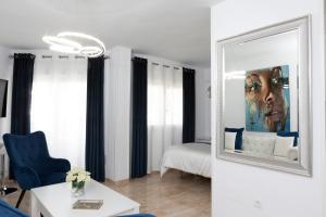a living room with a mirror and a blue chair at Acapulco playa Nerja 407 planta superior in Nerja